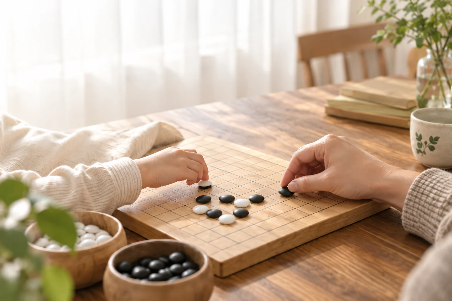 A parent and child sit across a wooden Go board, ready to play together.